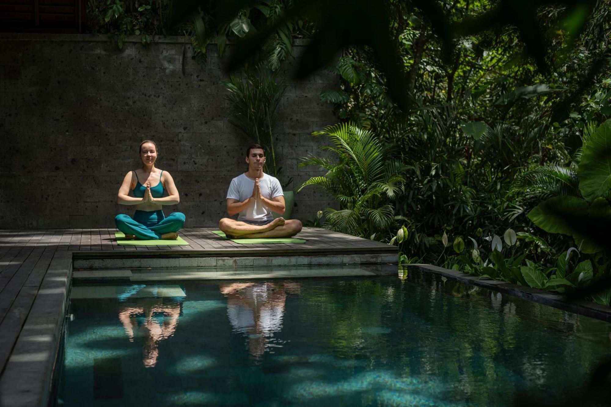 Adiwana Suweta Ubud Exterior foto A couple practicing yoga at the Bvlgari Spa